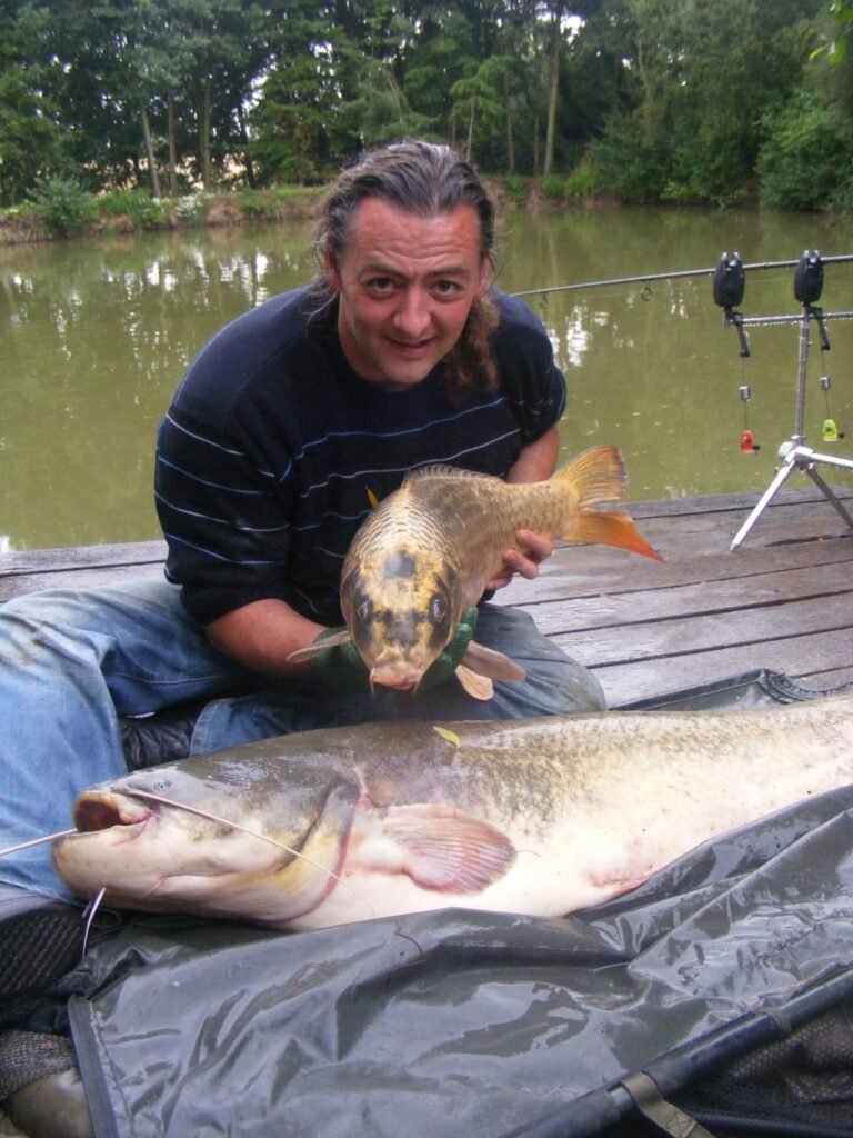 Simon Newcombe holding a carp while fishing